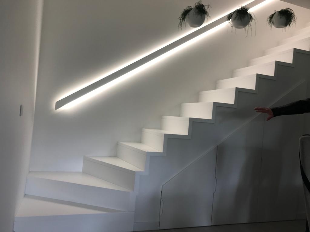 Białe schody dywanowe z podświetlana barierką