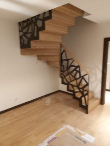 Drewniane schody dywanowe z czarną balustradą